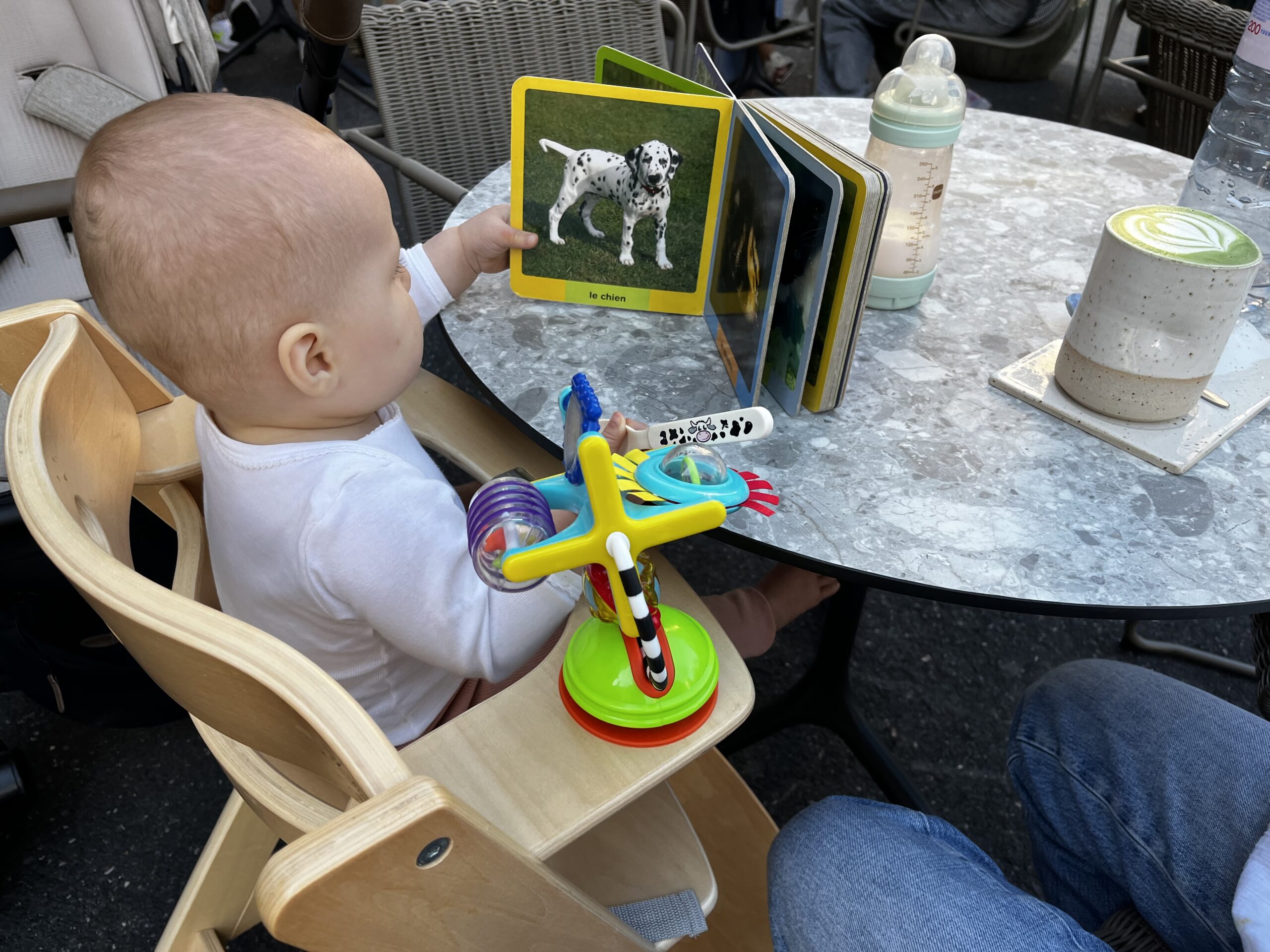 Patachou dans une chaise haute au Café Alba avec son imagier et un matcha