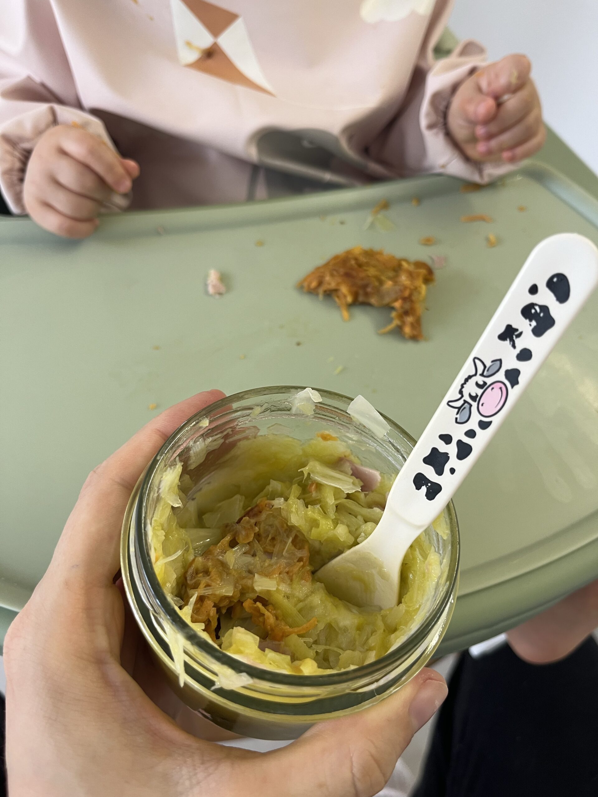 Un petit pot et sa cuillère devant Patachou installée pour son repas.