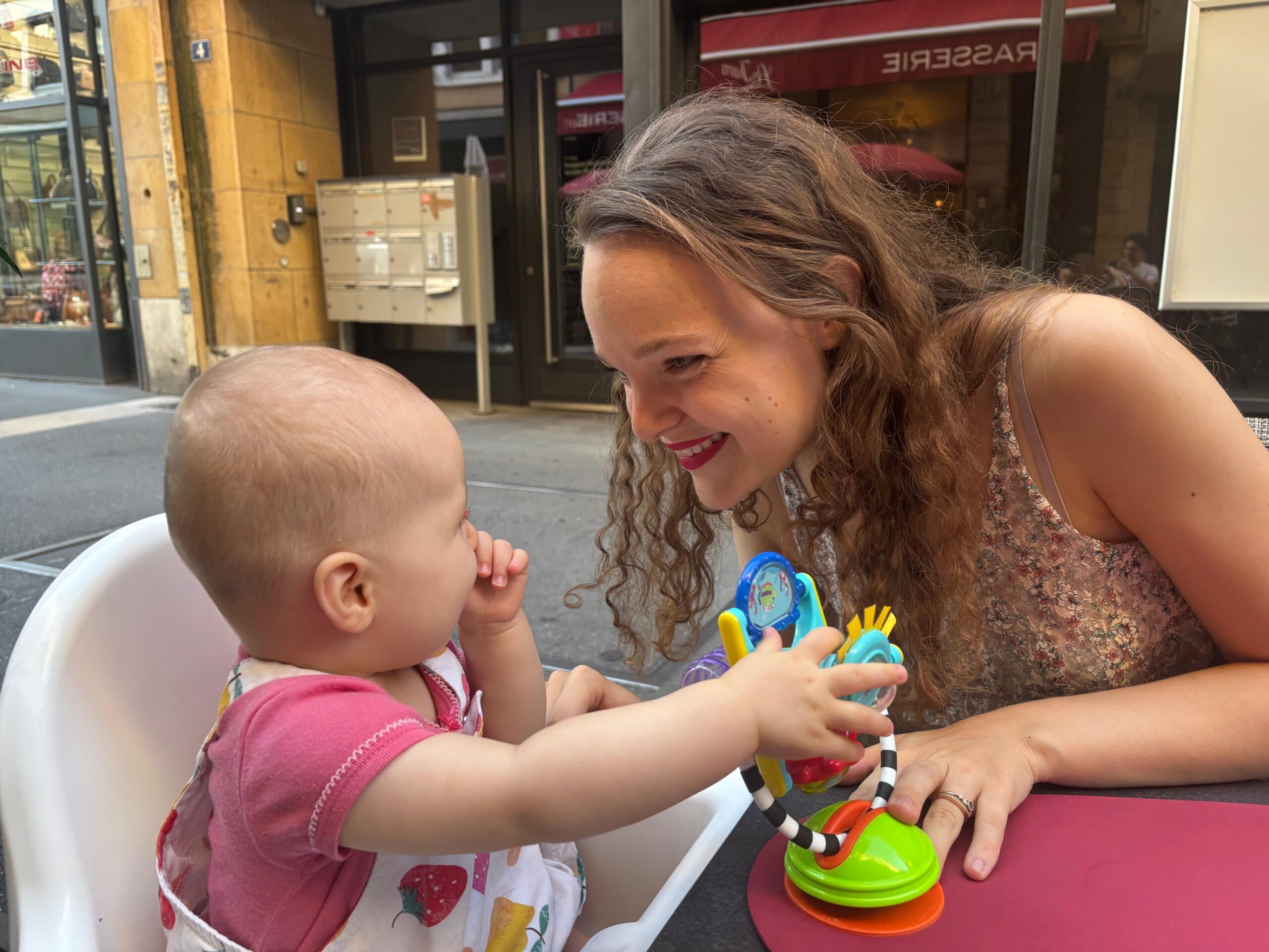 Un moment de complicité avec bébé dans sa chaise haute, en terrasse.