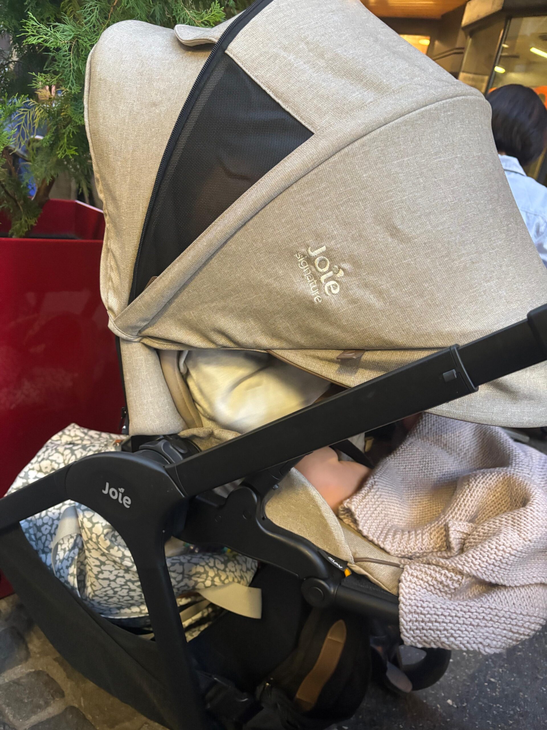 La poussette de bébé installée à côté de notre table en terrasse.