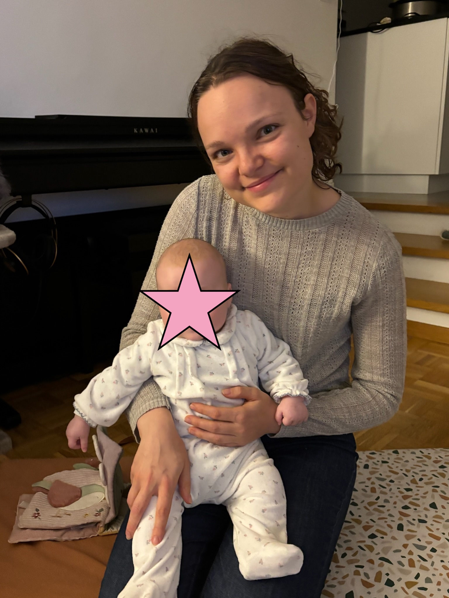 Mamanboussole assise avec son bébé sur les genoux.